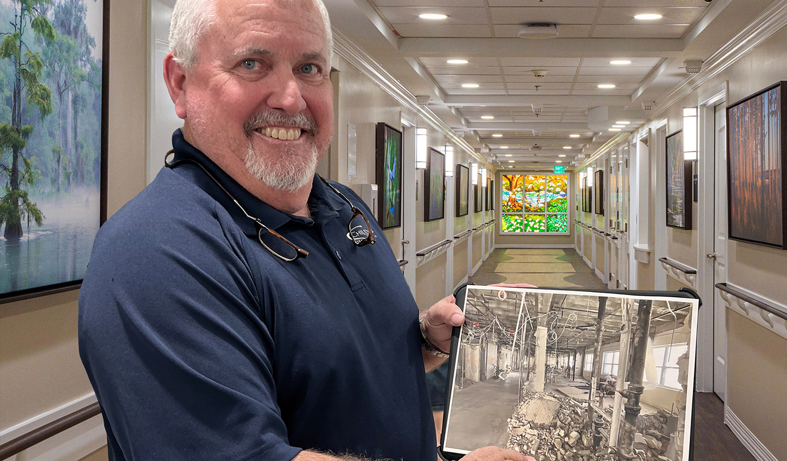 Robert Kuhn holding a photo of the demolished TMH wing in front of the completed main corridor of the FCCCC