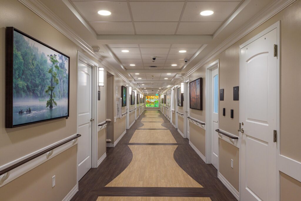 The view down the main hallway at the First Commerce Center for Compassionate Care featuring a stained glass wall from FSU Master Craftsman Studio.