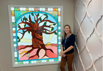 Ruth Nickens standing by the recently installed stained-glass window