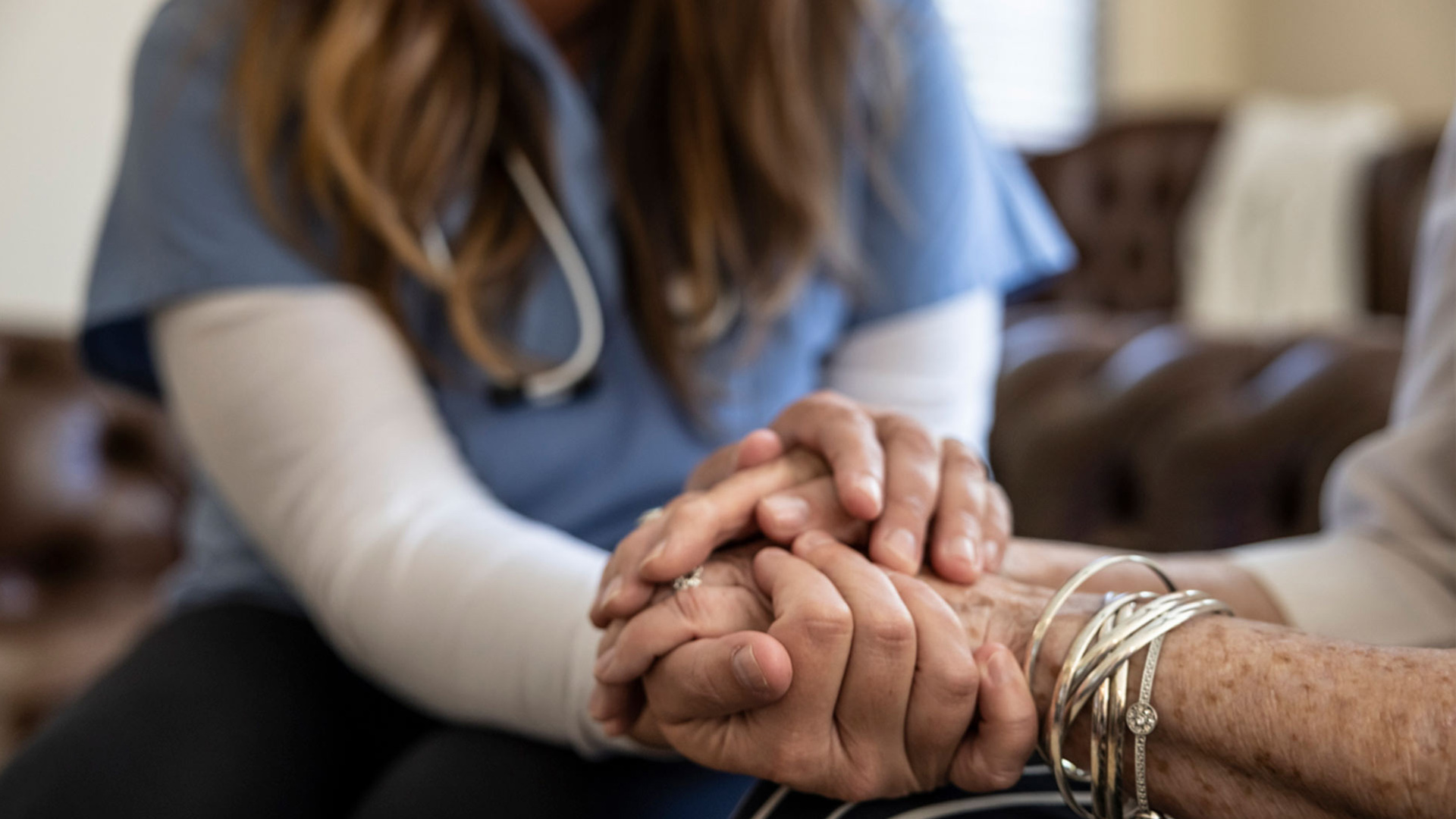 CNA holding hand of patient